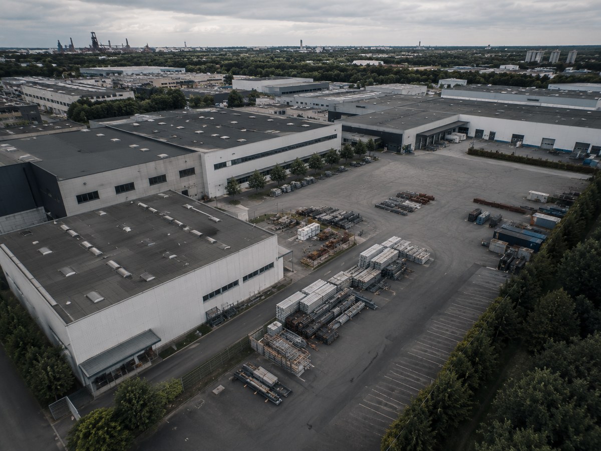 Produktionshalle und Freiflächen eines Industriestandorts aus der Luft